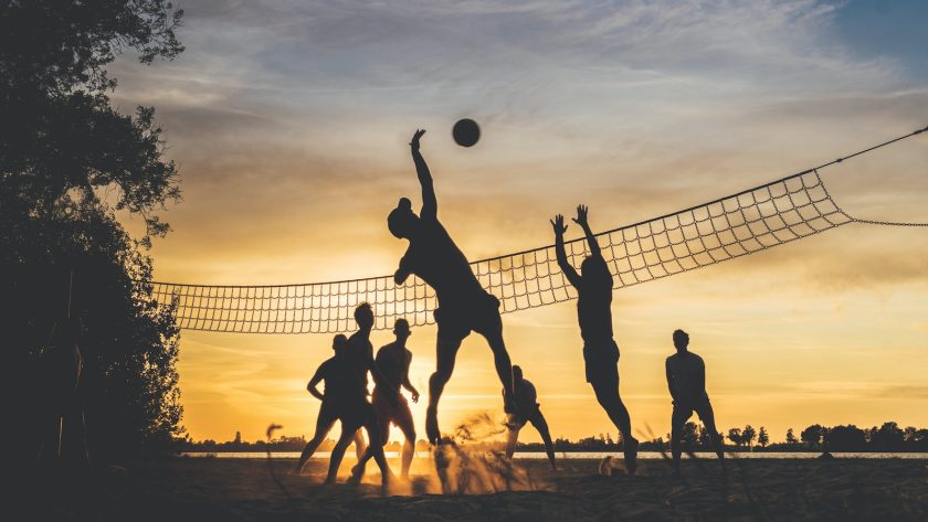 silhouette of people playing basketball during sunset