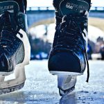 close-up photo of black-and-gray Intruder ice skates on frozen body of water