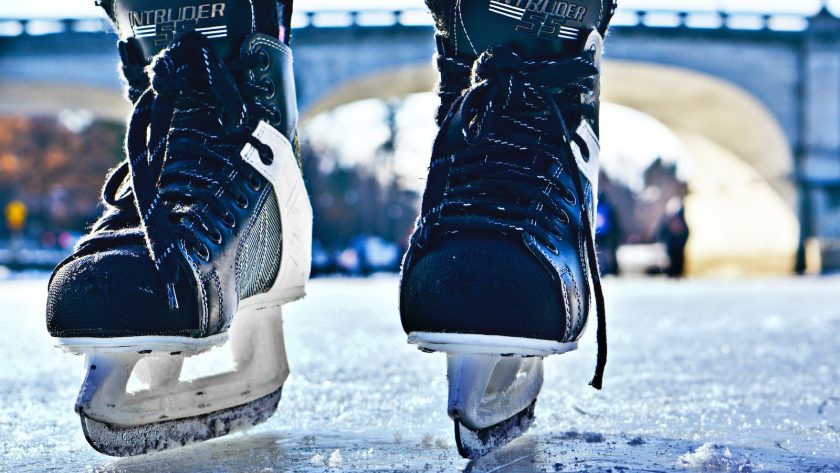 close-up photo of black-and-gray Intruder ice skates on frozen body of water